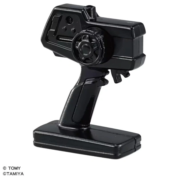  Black toy remote control with steering wheel and trigger, on a stand.