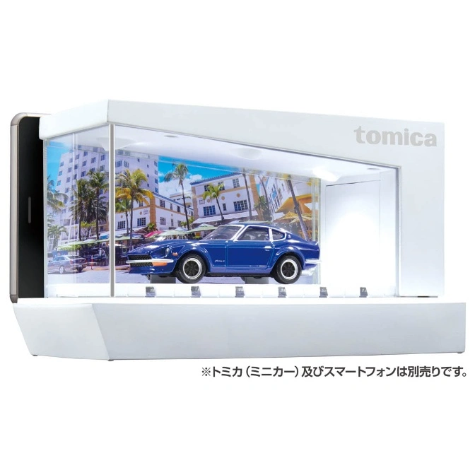 Blue toy car in a display case with a Miami backdrop and a phone attached.