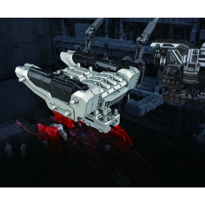  Silver and black toy spaceship being lifted by robotic arms in a futuristic setting.