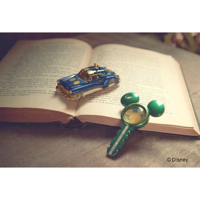  Toy car and Mickey Mouse key on an open book. Disney copyright visible.
