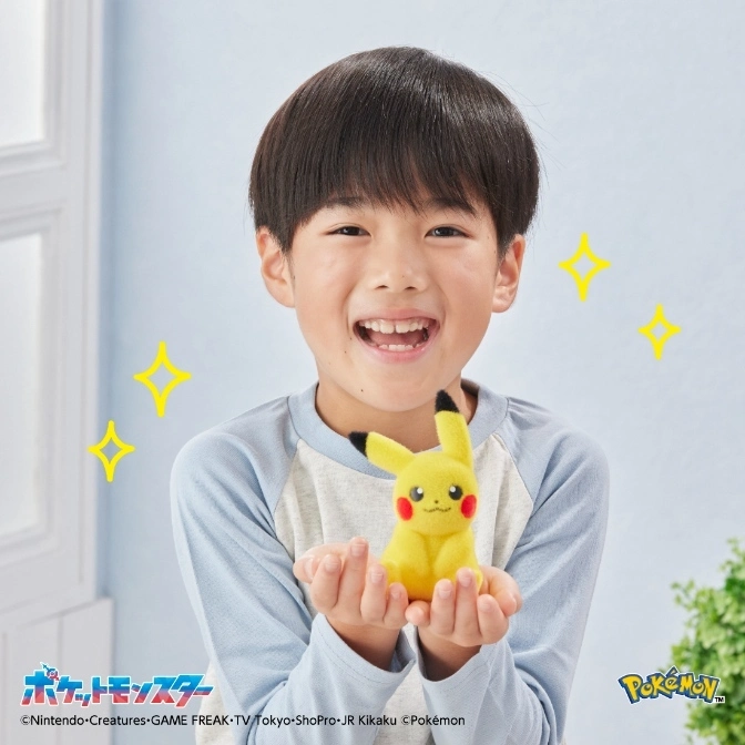  Smiling child holding a yellow Pikachu plush toy with black-tipped ears.