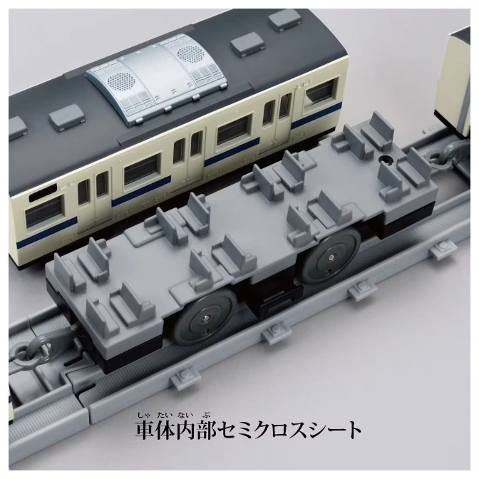  Toy train car with seats on a track next to a passenger car.