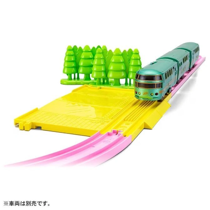  Toy train on a yellow and pink track with green trees.