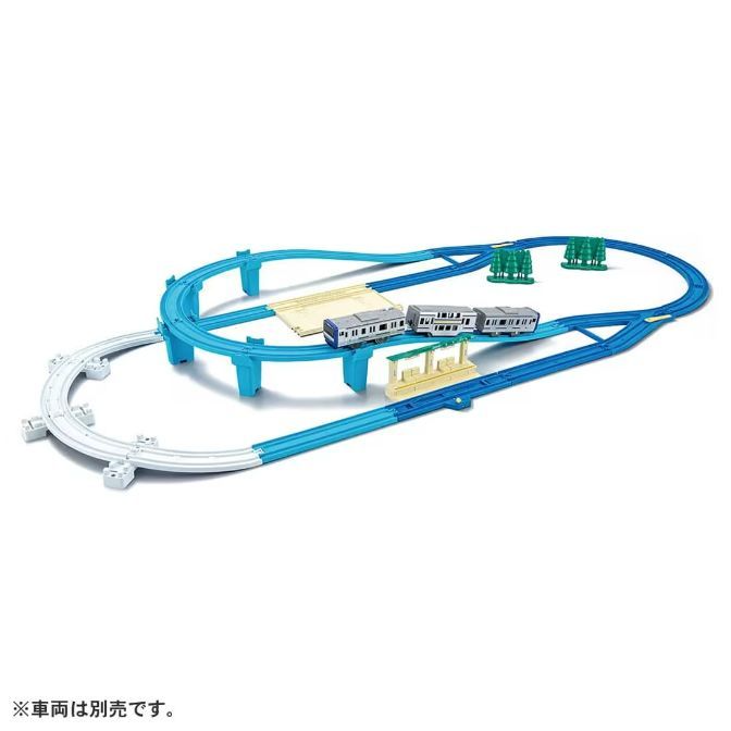  A toy train set with blue and white tracks, a bridge, a station, trees, and a train.