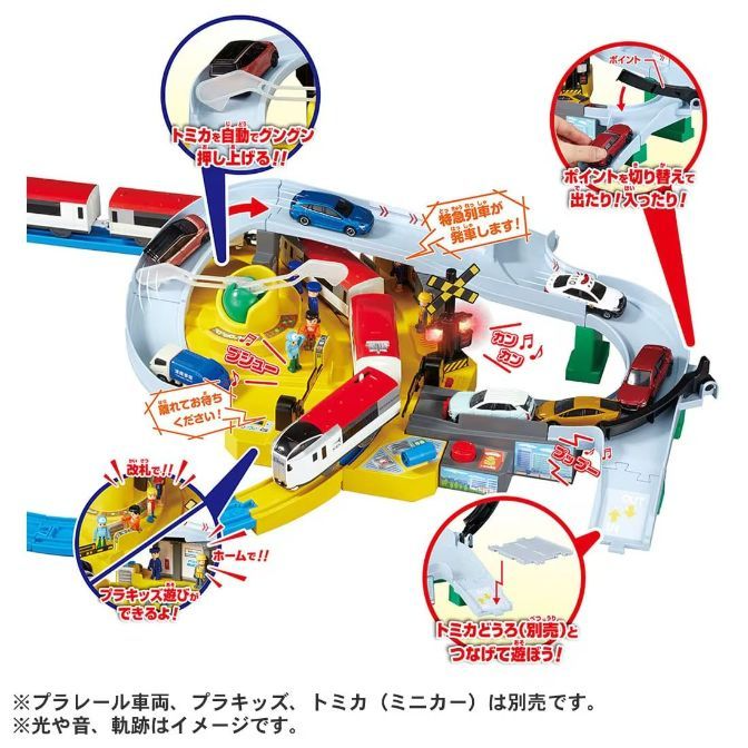  A toy set featuring a train and cars, with various interactive elements such as a car lift, a train station, and a switch to change the direction of the cars.