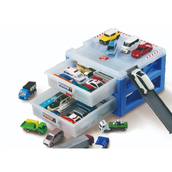 Toy car parking garage with cars on top and in drawers, plus other toy vehicles nearby.