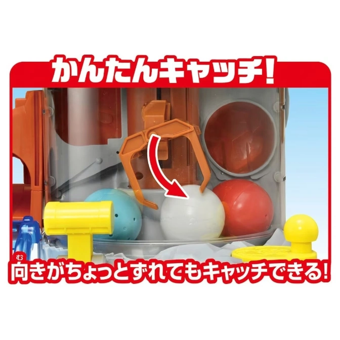  Toy crane game with colorful balls and an orange claw grabbing a white ball.