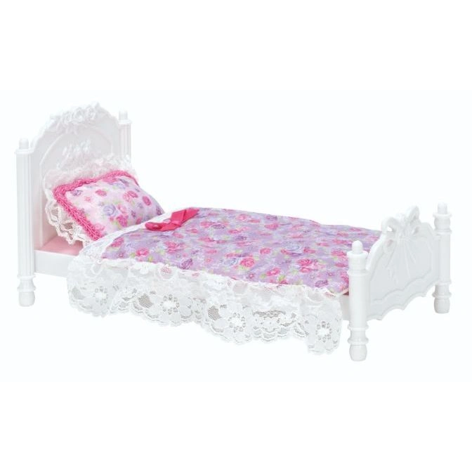  White doll bed with floral bedding and lace trim.