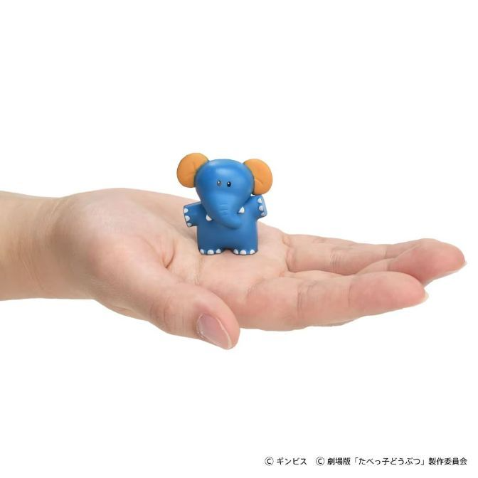  Blue elephant toy with orange ears held in a hand.