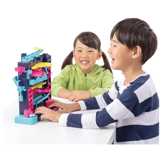  Kids playing with a colorful ball run toy with ramps and tracks.