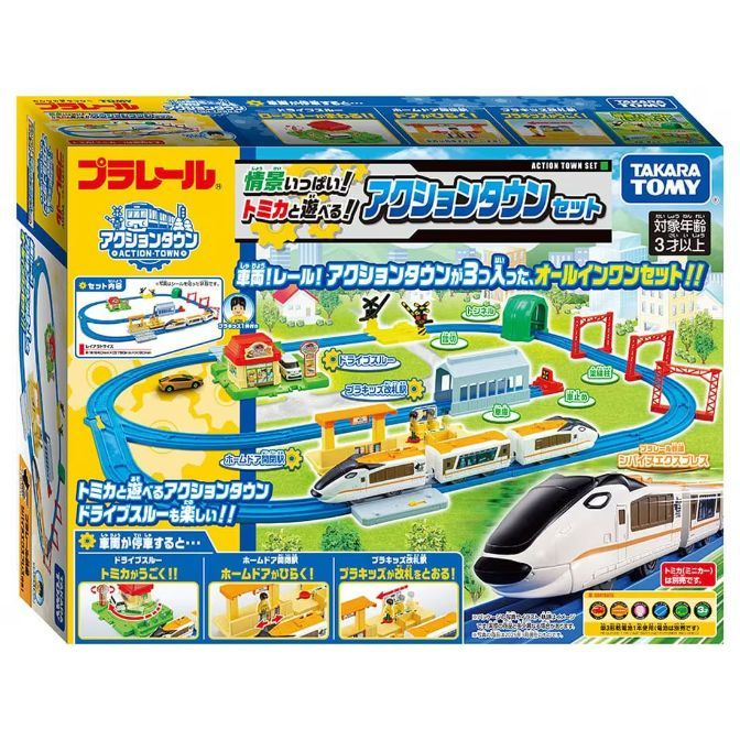  The product image shows a Takara Tomy Plarail Action Town Set box. The box features a train set with various interactive elements, including a drive-through, a station with opening doors, and a ticket gate with figures. The set includes a train, tracks, and accessories to create a miniature town environment. The box also displays the product name, brand logos, and age recommendation.