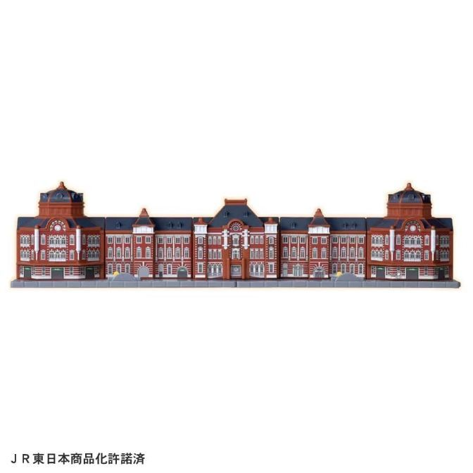 A miniature model of the Tokyo Station building, featuring its distinctive red brick facade and domed towers.