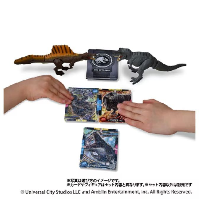  Spinosaurus and T-Rex toys with Jurassic World cards being played by hands.